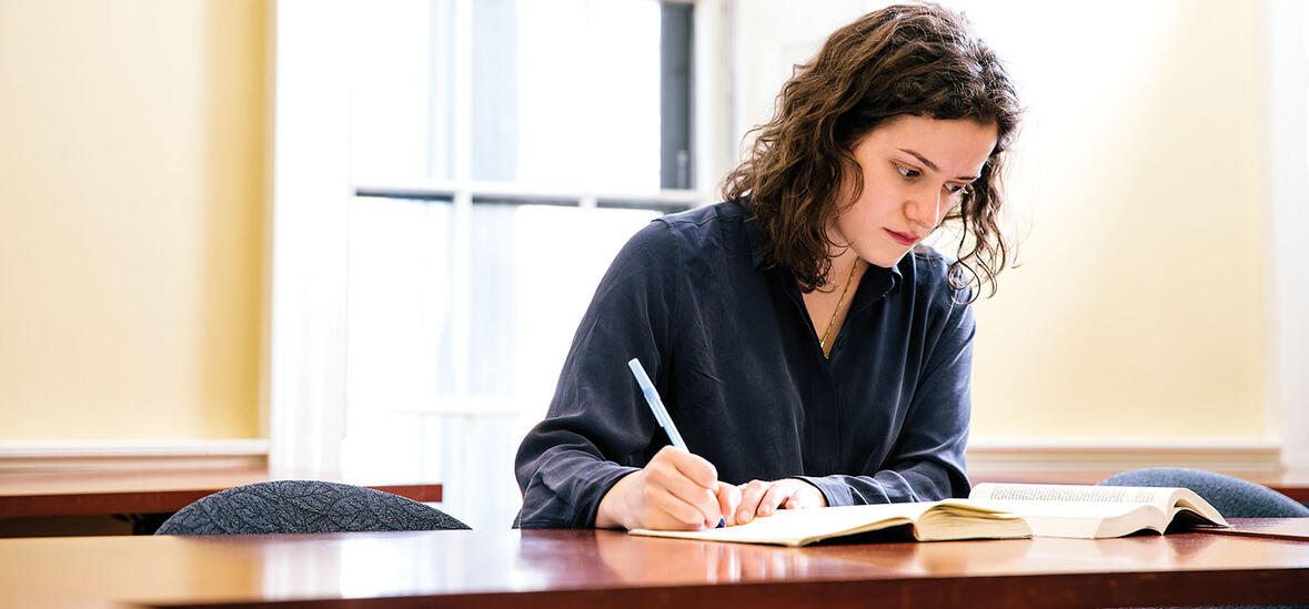 Lusia Zaitseva writing at a desk