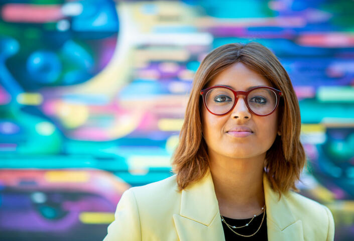 Nabiha Saklayen standing in front of a colorful mural