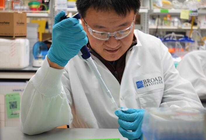 Liang Chang in lab holding tube