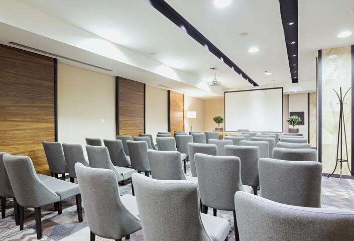 Conference room with gray chairs and screen in the back