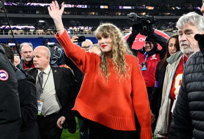 Pop singer Taylor Swift waves to the crowd at a Kansas City Chiefs football game