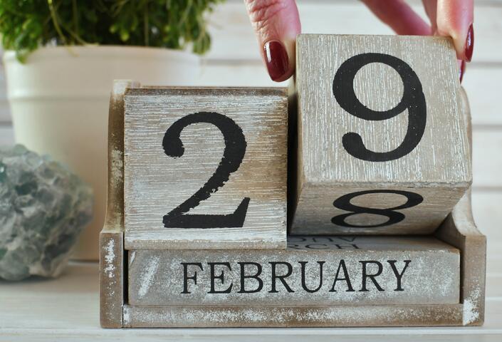 hand turning calendar date to February 29