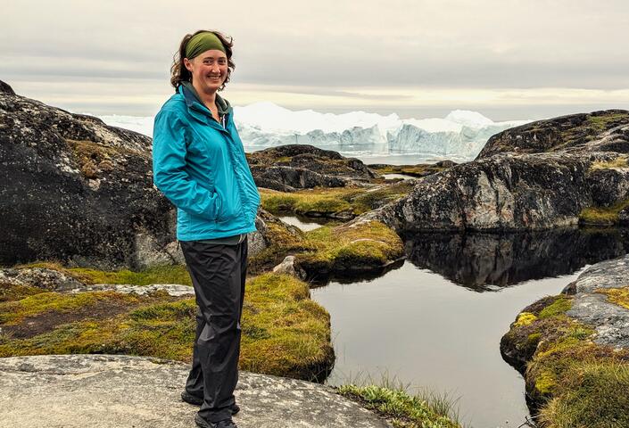Kara Hartig standing in front of an iceberg