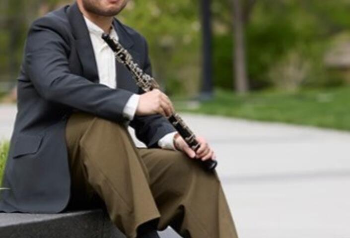 Graduating student Matt Lee sitting on a ledge