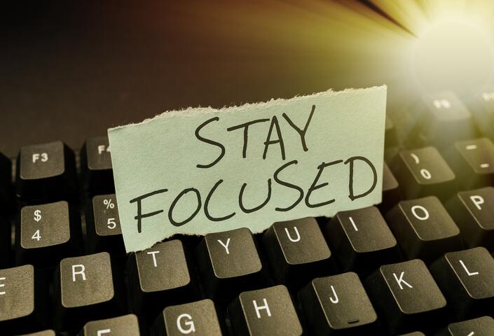 keyboard with handwritten note on it that says, "Stay Focused"
