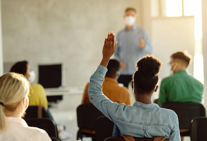 Black student raises hand in classroom