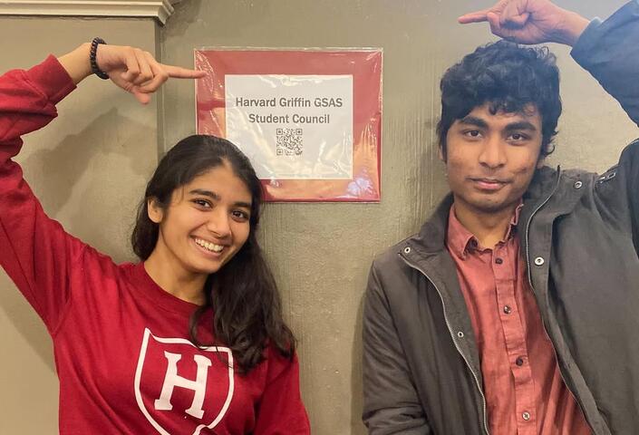 Victor Arul and fellow peer pose with GSC signage