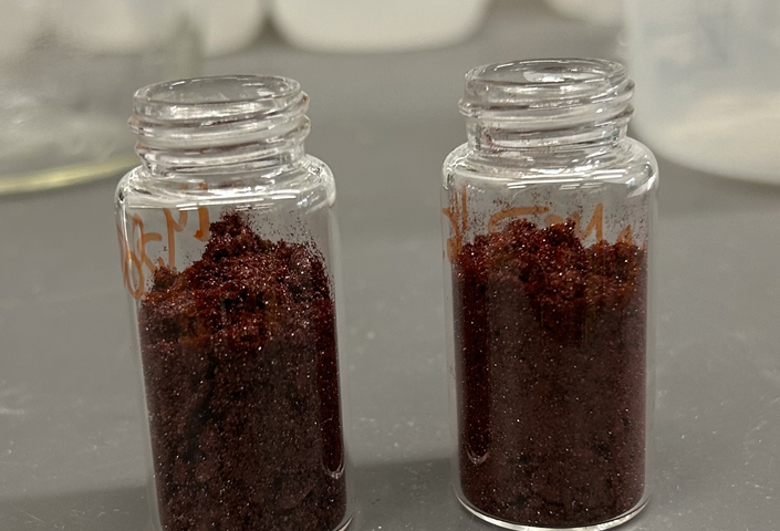 Two vials containing Campbell’s Silver 2+ photocatalyst: a vibrant, microcrystalline red powder that can be isolated on gram-scale in an analytically pure fashion. 