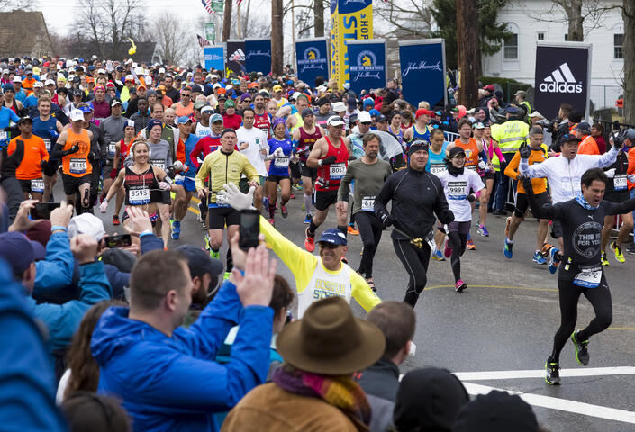 a wave of enthusiastic runners beginning the Boston Marathon