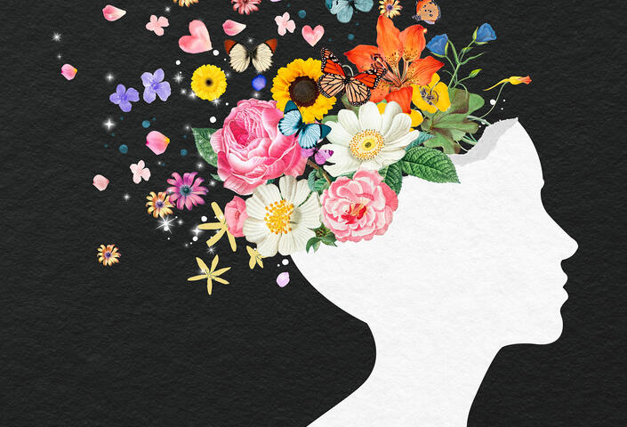 silhouette of face, with flowers and butterflies emerging from top of head, representing positive mental health
