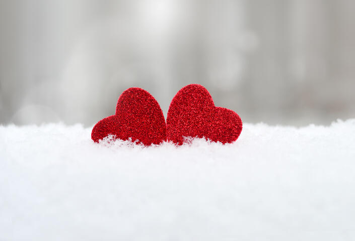 two red hearts in a pile of snow