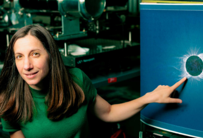 Astrophysicist Jenna Samra pointing at an image of the sun