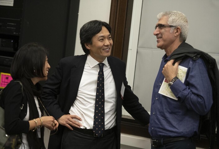 Three alumni converse casually in Emerson Hall