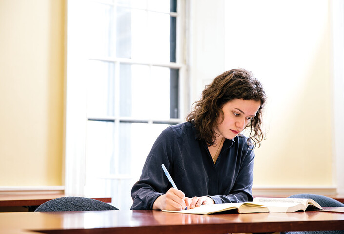 Lusia Zaitseva writing at a desk