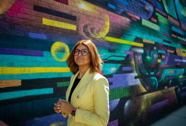 Nabiha Saklayen standing in front of a color mural