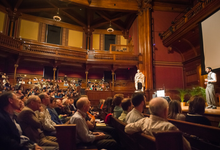 Student on stage in front of crowd at Sanders Theatre