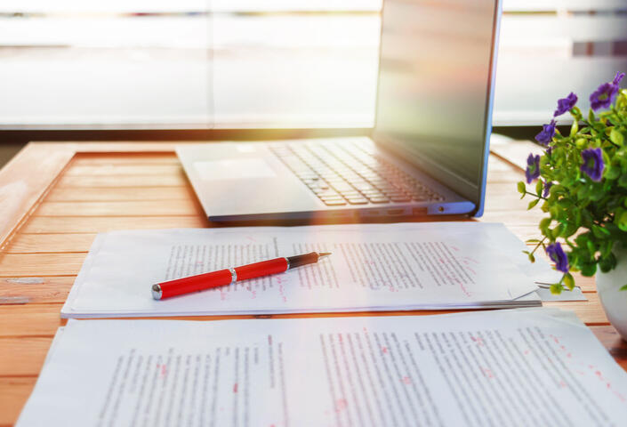 Laptop with notebook and pen