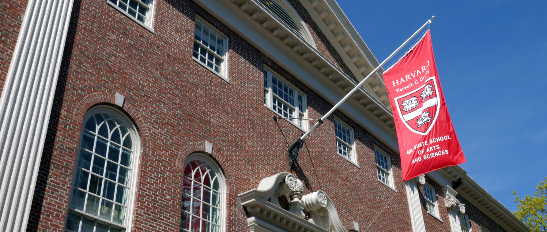 Exterior of Lehman Hall with Harvard Griffin GSAS flag displaying