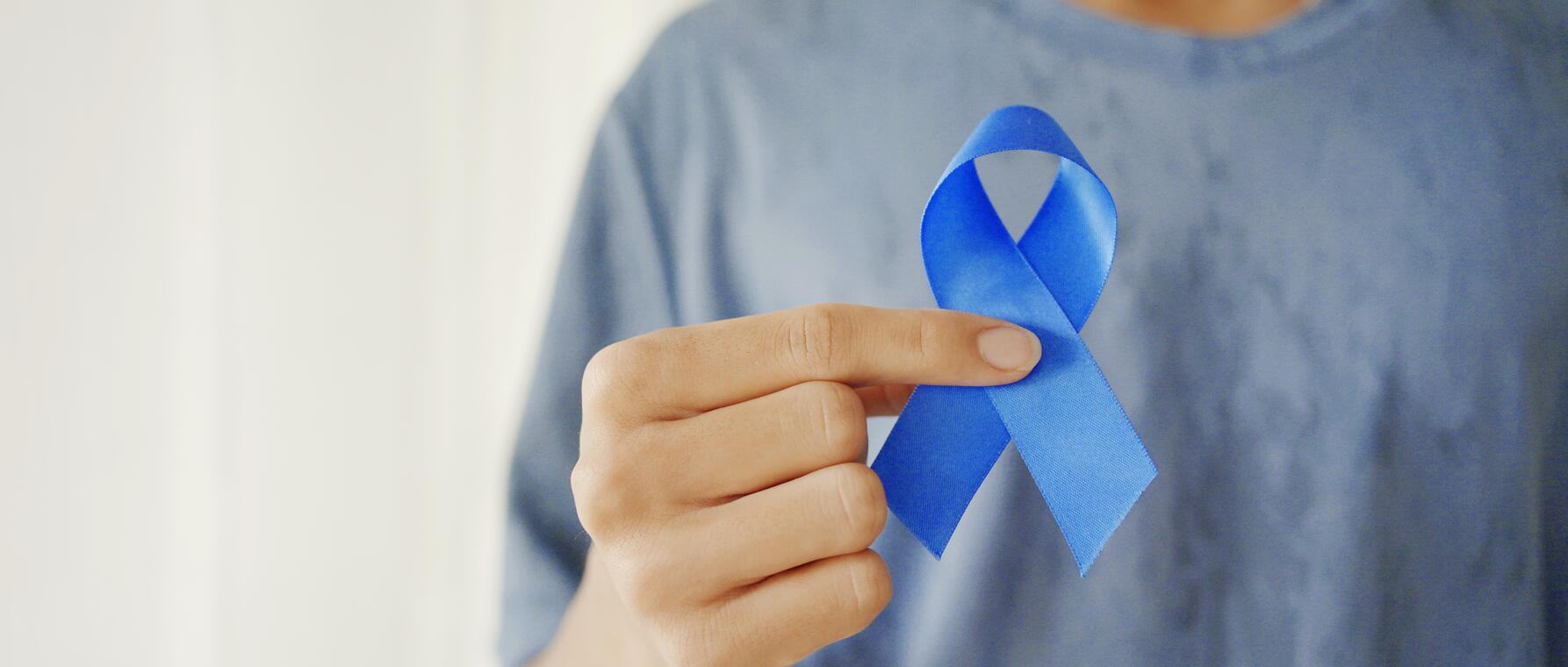person holding blue prostate cancer ribbon