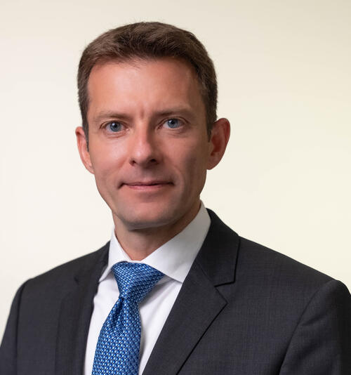 headshot of Thomas Mertens, man in blue tie and black suit jacket