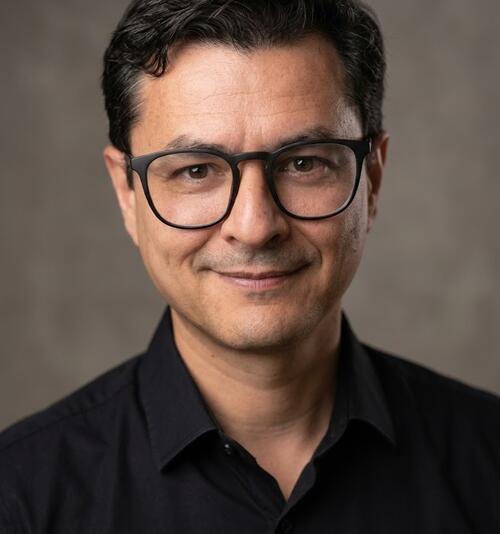man, in a black shirt, wearing glasses