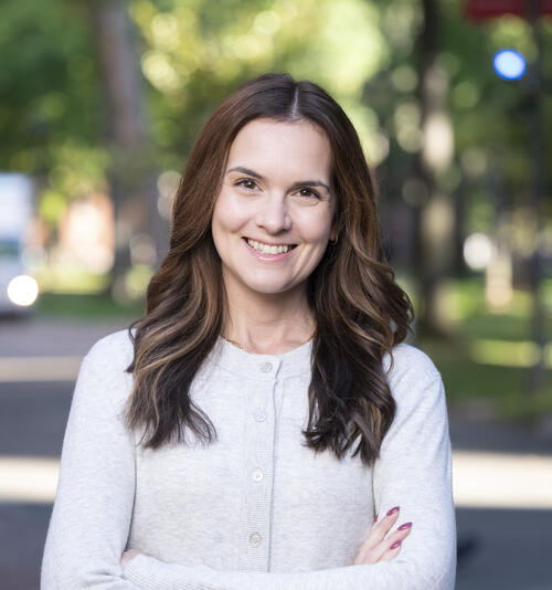 Emily Crowell headshot; brunette smiling wearing gray cardigan