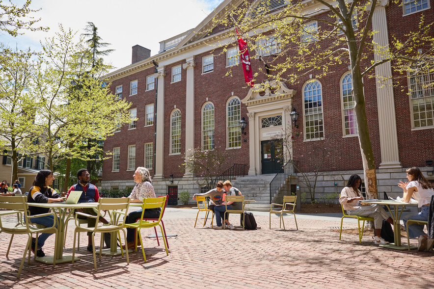 Lehman hall exterior on a sunny day with students socializing outside