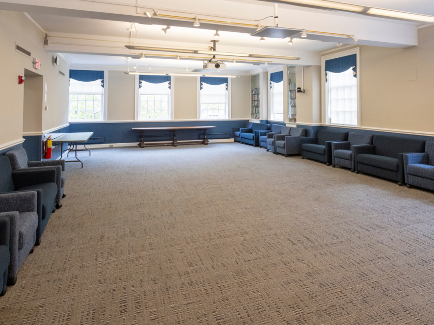 Large room lined with blue couches