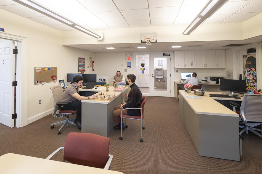 An office space with desks and people playing chess