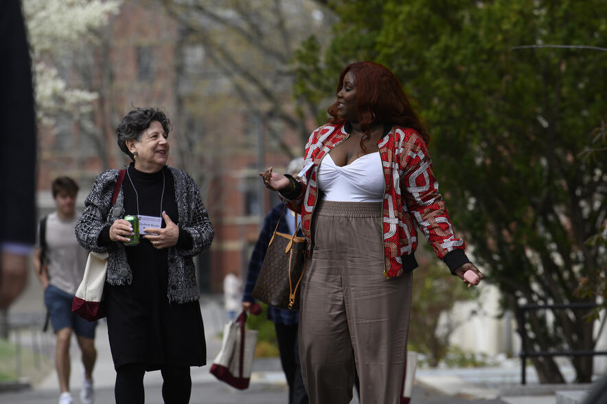 Two Harvard Griffin GSAS alumni walking and chatting outdoors