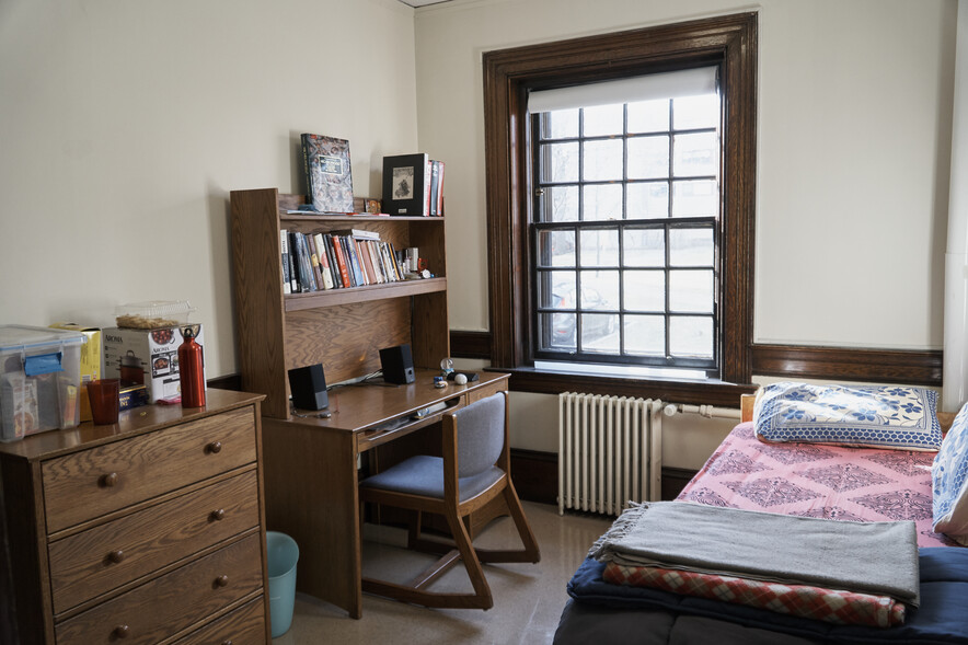 Small, occupied room in Perkins Hall with desk, chair, bed
