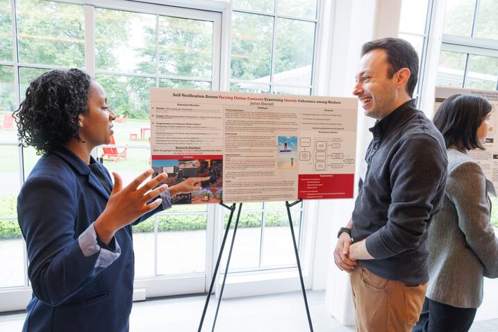 Sherrell presenting a poster to a faculty member
