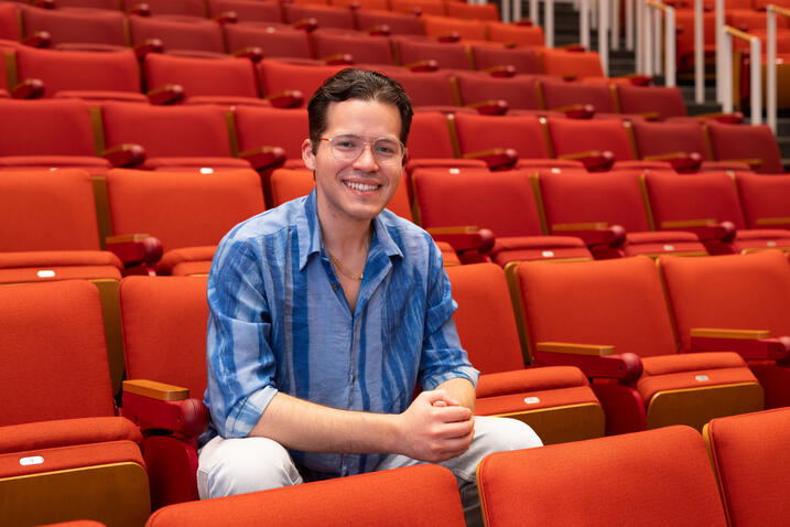 José Del Rio Pantoja sitting on red lecture hall chairs
