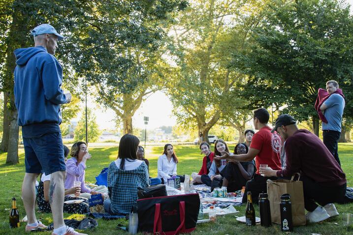 Graduates hanging out on the lawn during a picnic