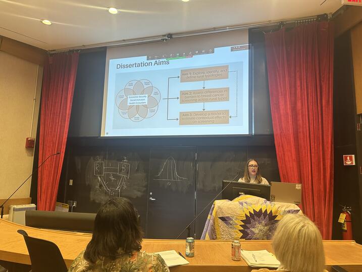 Jennifer Cruz during her PhD defense; standing at podium with powerpoint in background