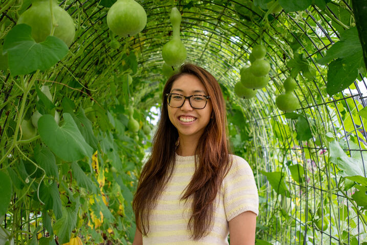 Melissa Mai headshot; standing in front of green trees