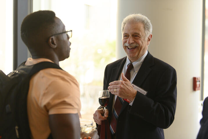 Two Harvard Griffin GSAS alumni smiling and talking