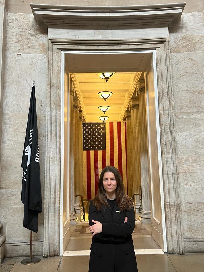 Anastasiia standing in front of USA flag