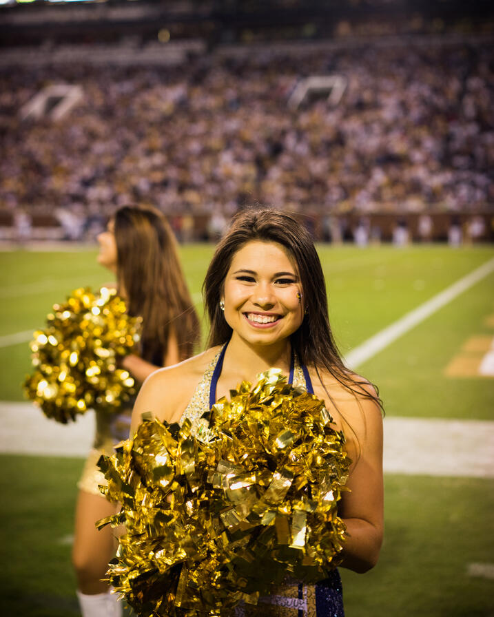 Abigail in dance and cheer gear on a football field