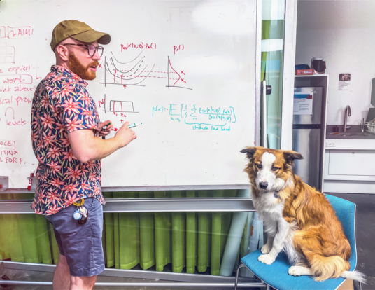 Yaniv Yacoby explaining his research to his dog, Paigu, and others (not pictured).