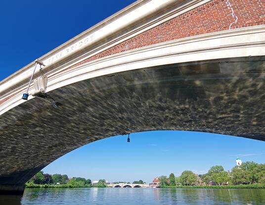 view from the Charles River passing under Weeks footbridge