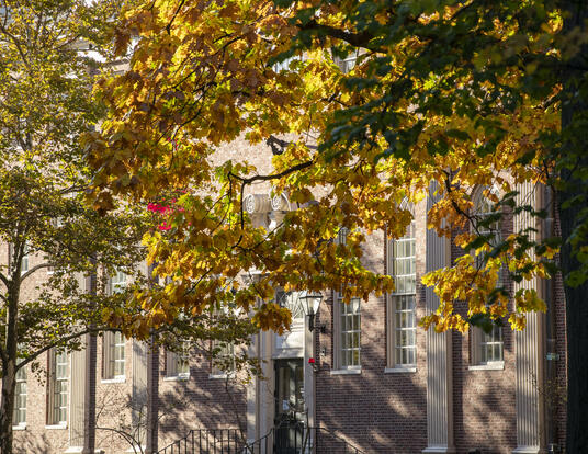 Lehman Hall, GSAS Student Center, through trees beginning to change colors