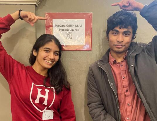 Victor Arul and fellow peer pose with GSC signage