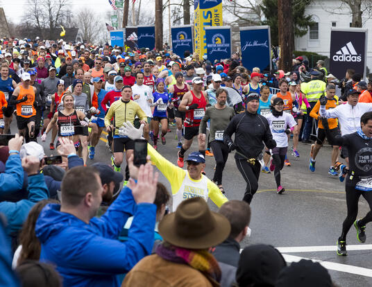 a wave of enthusiastic runners beginning the Boston Marathon