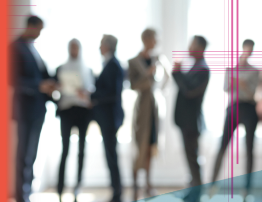 Blurred stock photo of six office workers speaking with each other. 