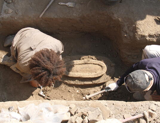 Melina excavating in a trench