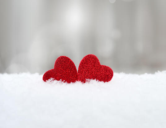 two red hearts in a pile of snow