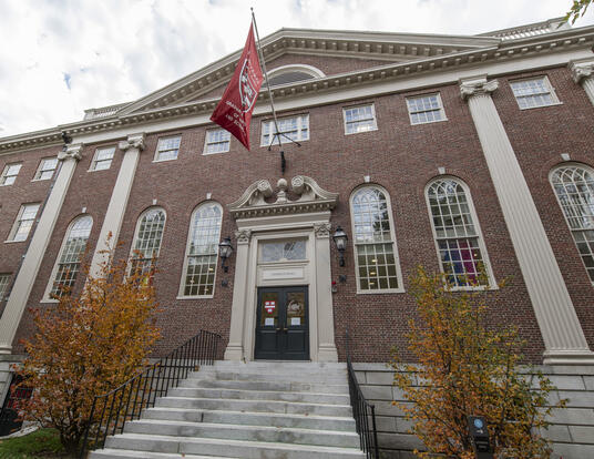 exterior of Lehman Hall with updated GSAS flag and fall leaves