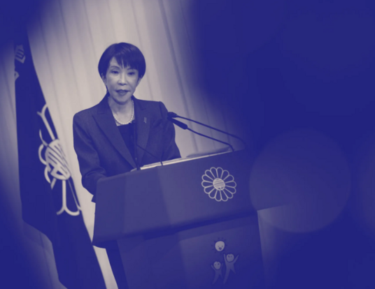 Black and white photo of Sanae Takaich, Japan’s Prime Minister, at a podium