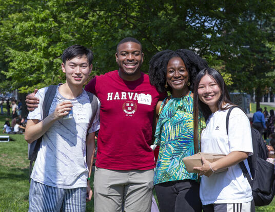 Four students smile together
